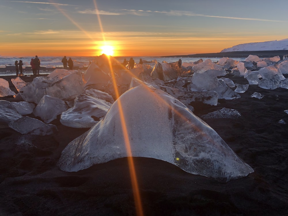 brick of ice on shore during golden hour