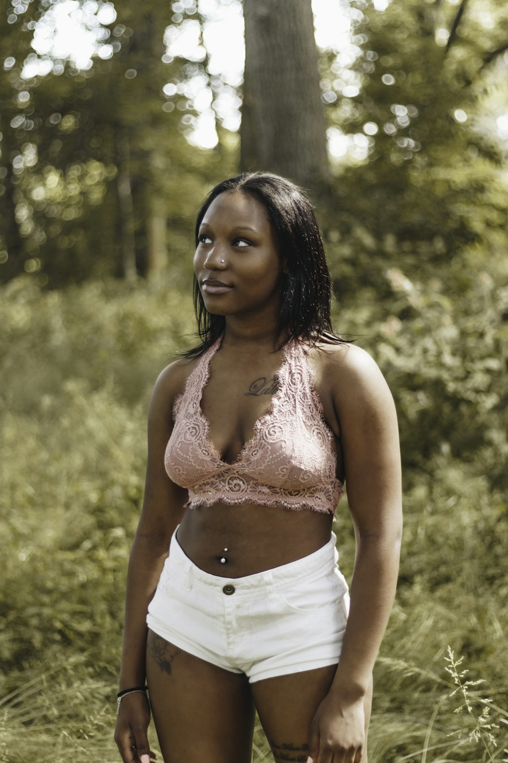 woman wearing pink lace crop top and white shorts