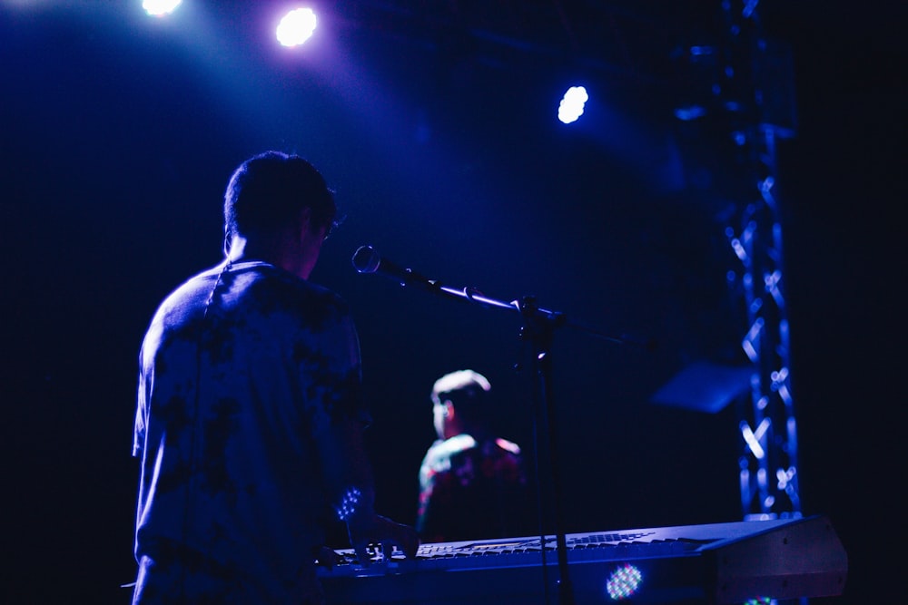 man playing electric keyboard on stage