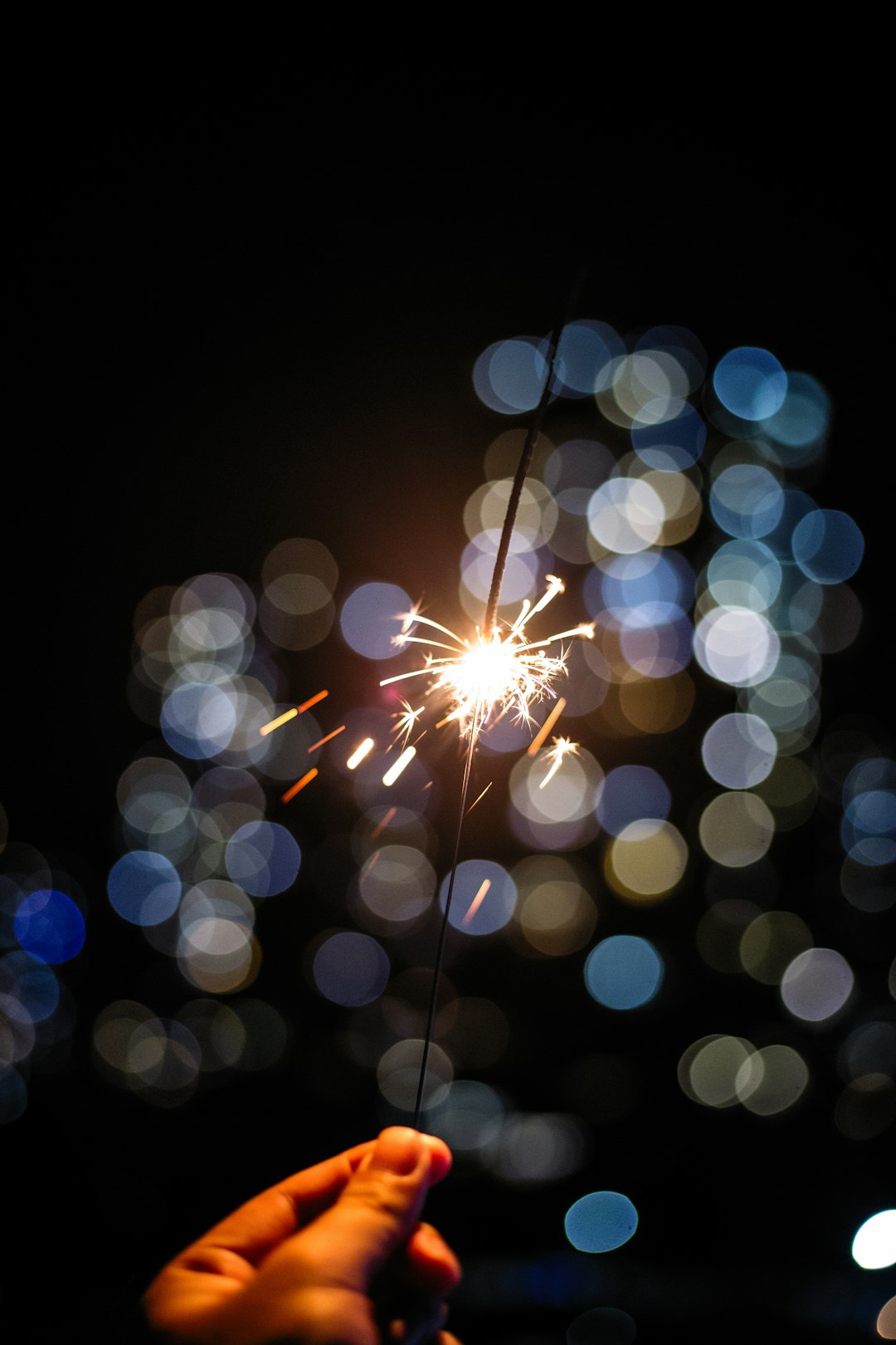 hand holding lighted sparkle stick