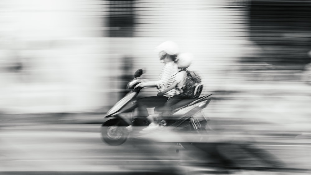 woman driving scooter with child speeding on road