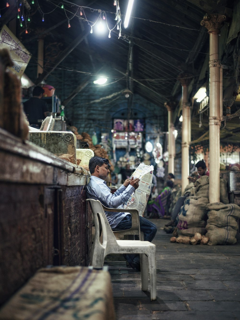 man reading a newspaper in a market