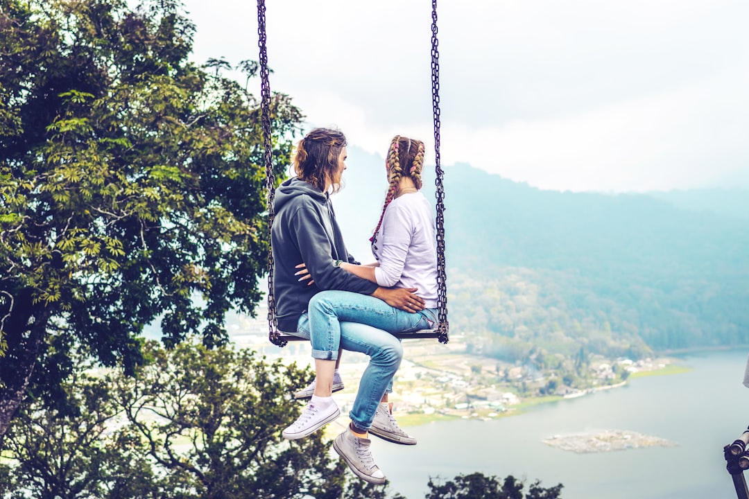 man and woman siting on swing
