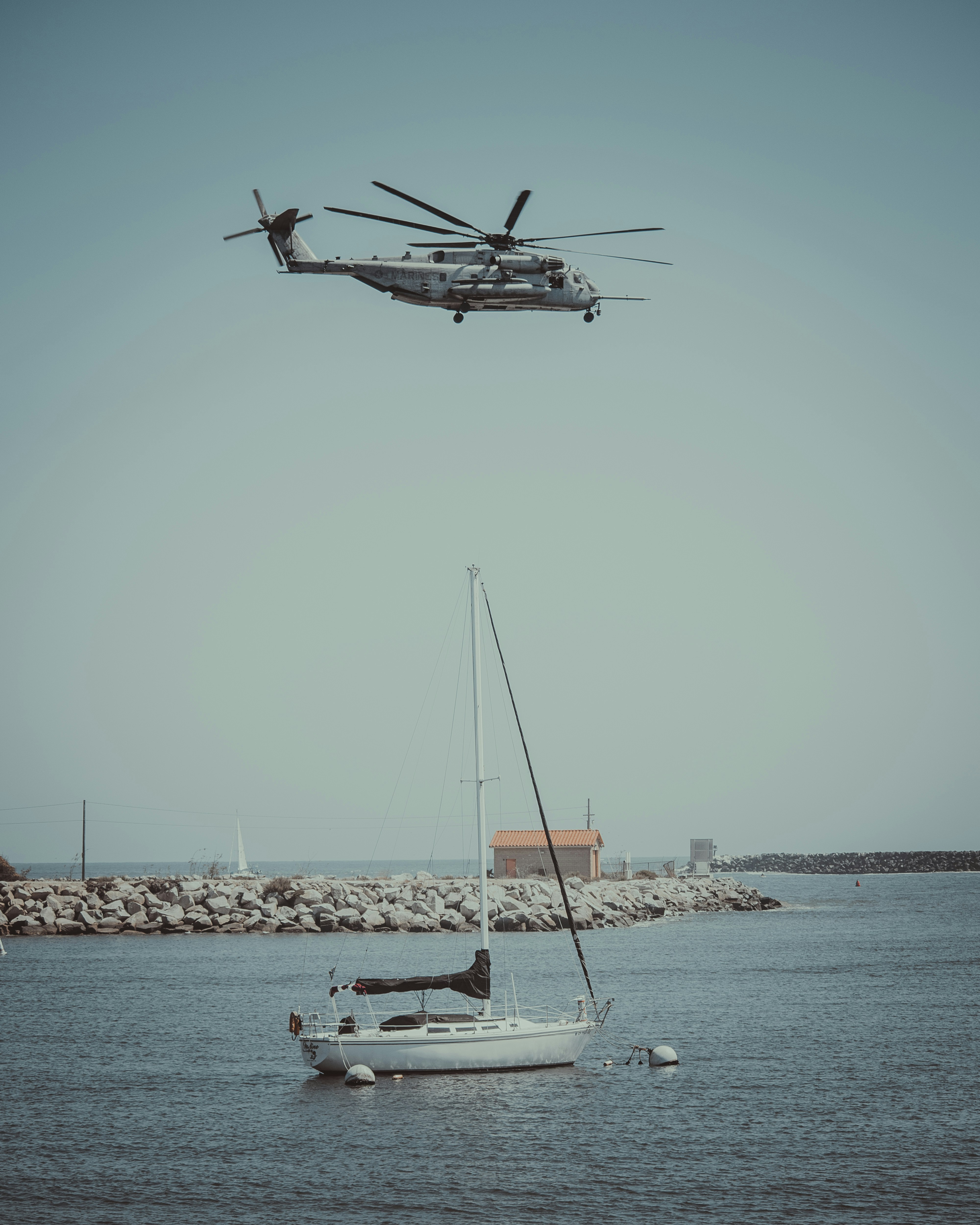 helicóptero branco voando sobre o iate ancorado