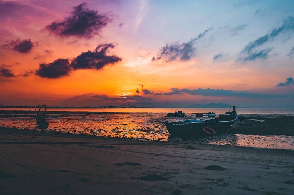 boat on seashore during golden hour