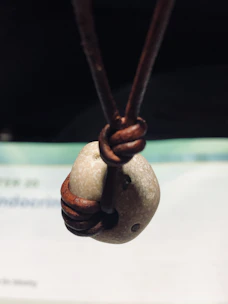 Man outdoors wearing a leather cord necklace with rustic metal details