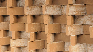 Close-up of handcrafted mushroom mycelium bricks stacked neatly in a rustic workshop.