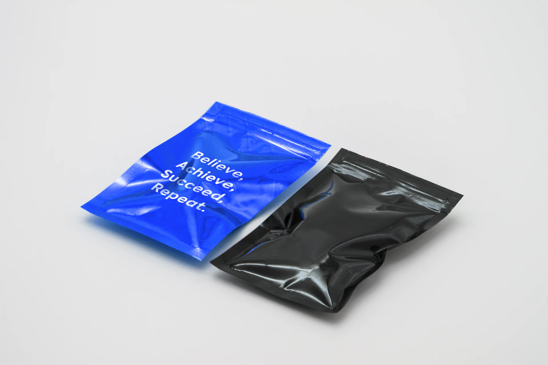 A printed blue pouch and a black pouch lying side by side