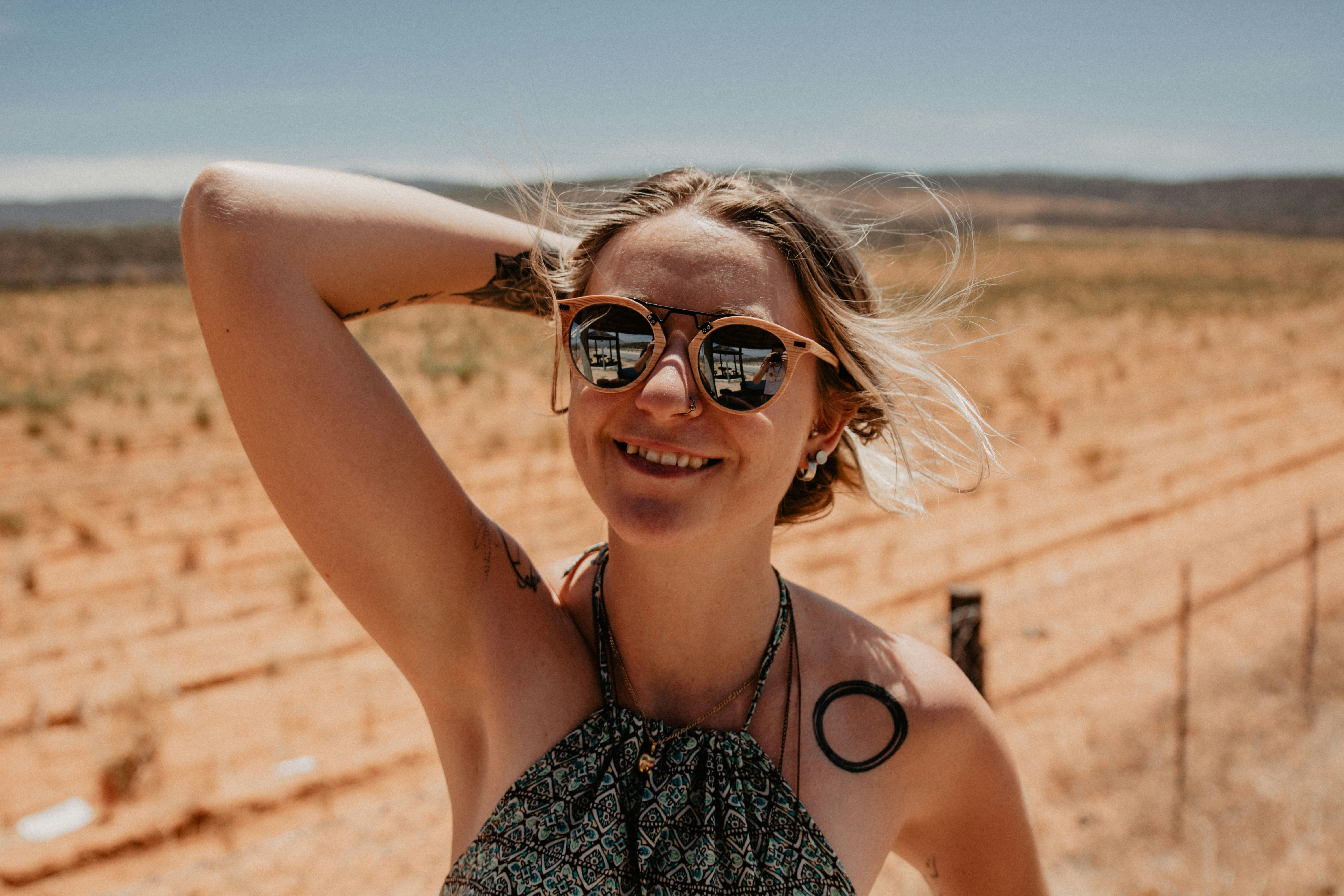 Woman smiling in sunny outdoor setting, warm afternoon light, relaxed expression