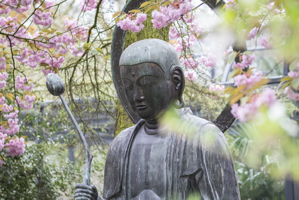 statue de divinité près de l’arbre