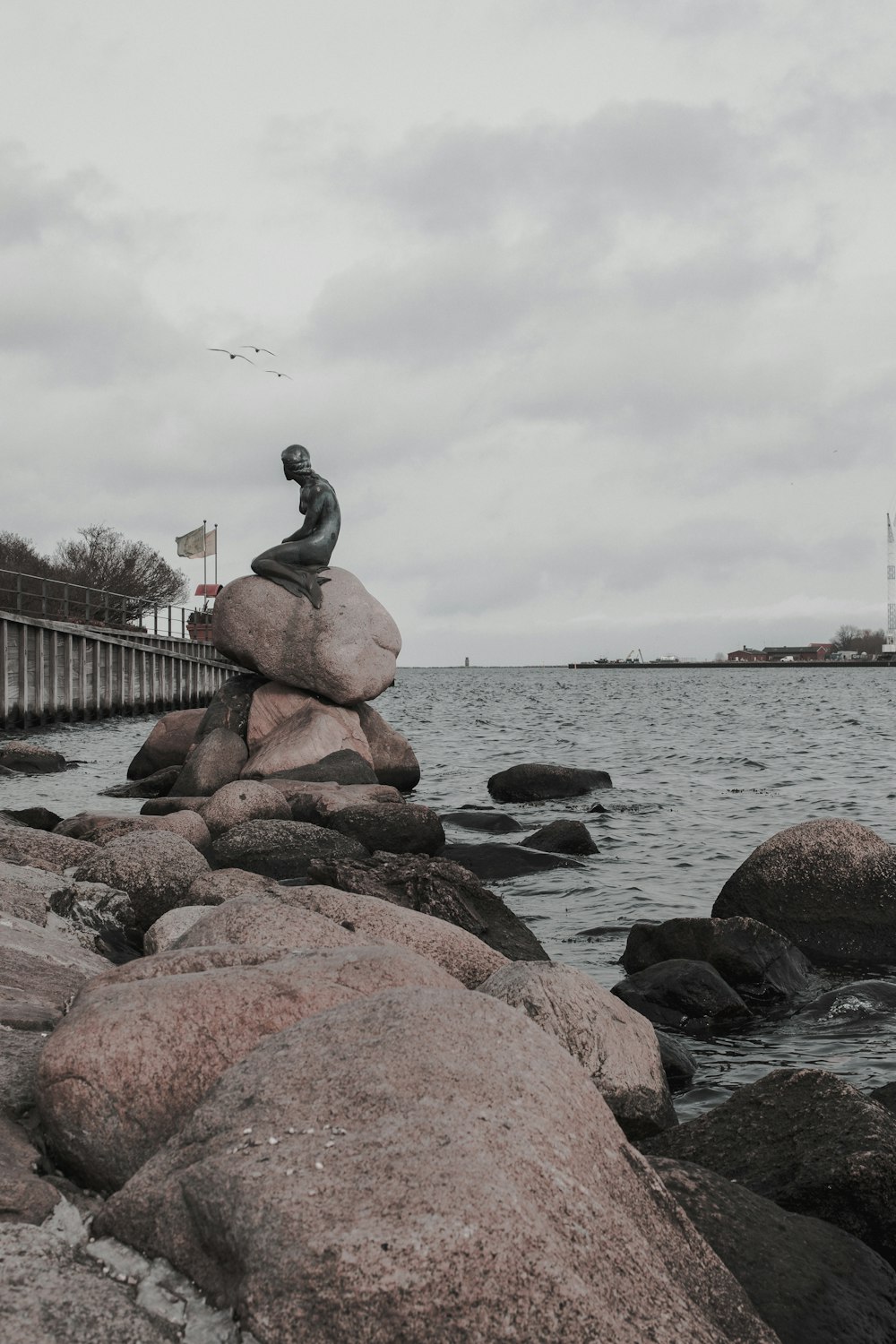 Statue humaine assise sur le rocher