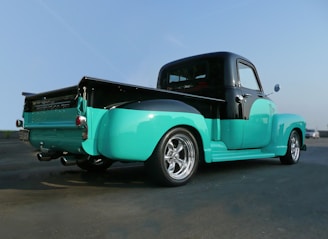 teal and black pickup truck on road