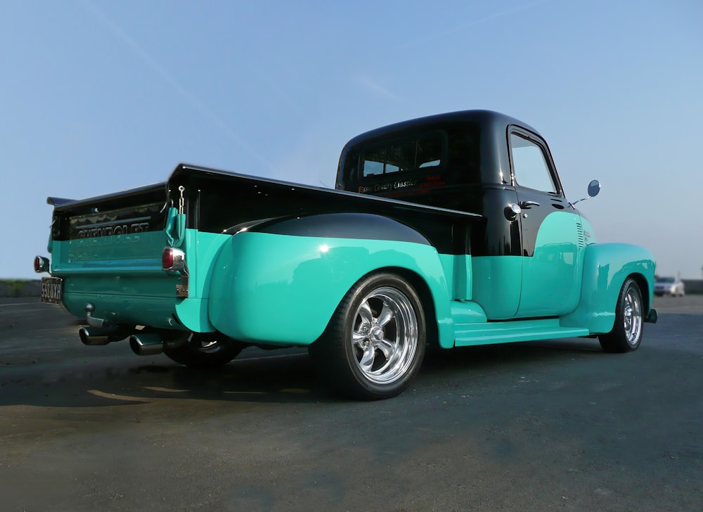 teal and black pickup truck on road