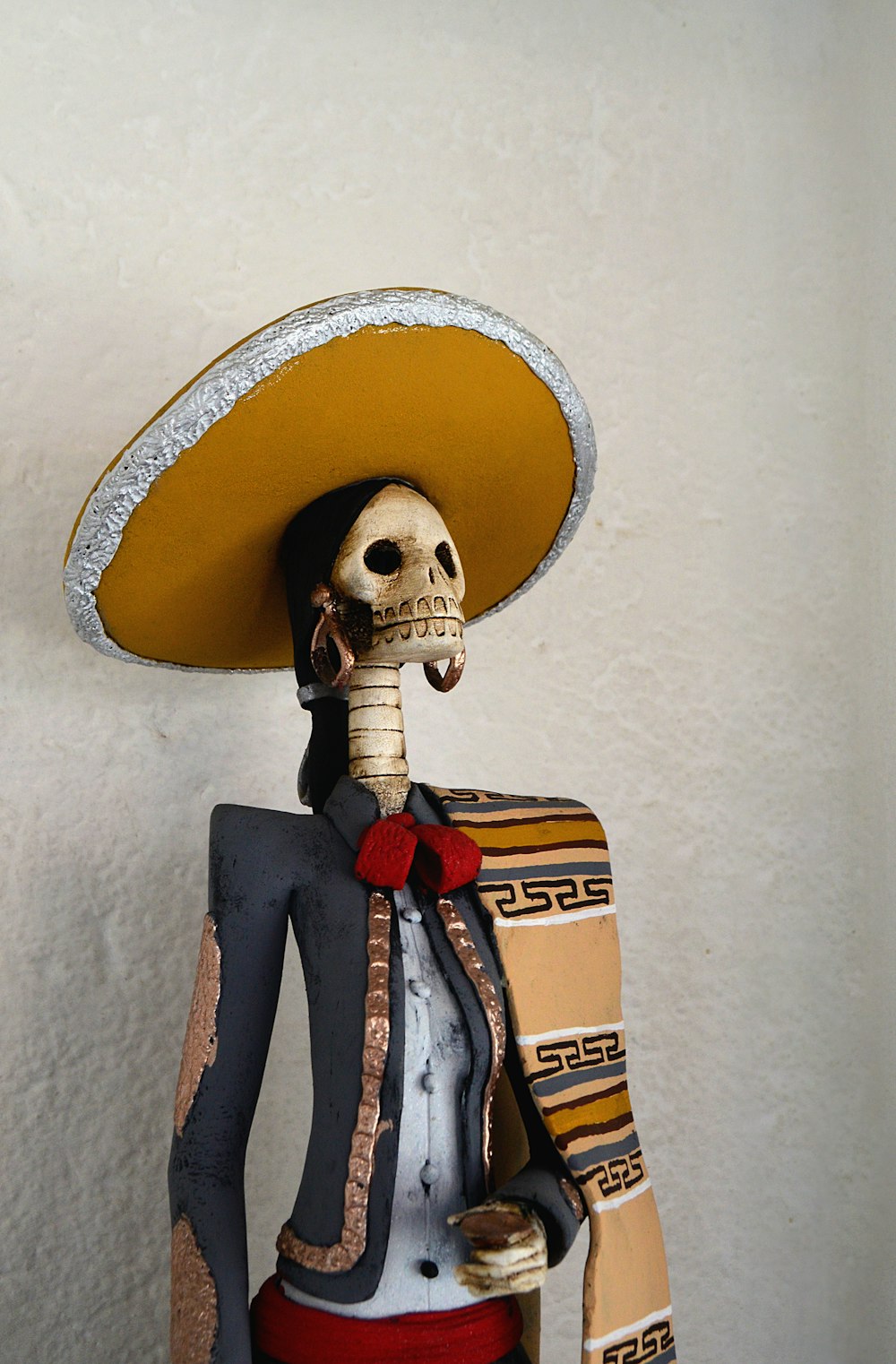 Day of the Dead statue near white painted wall