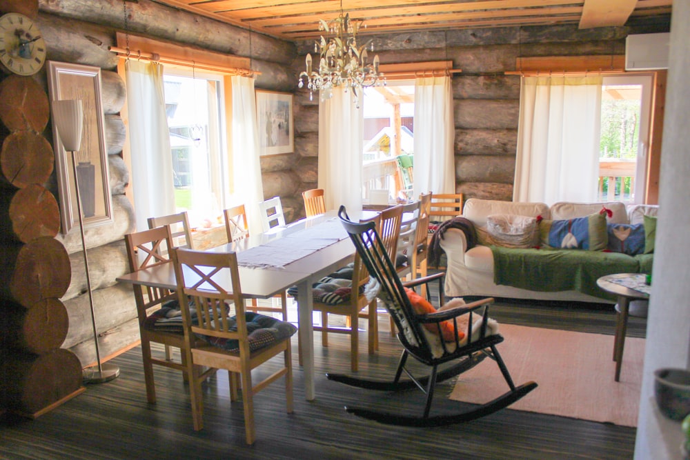 nine vacant chair near a brown wooden rocking chair in a room during daytime