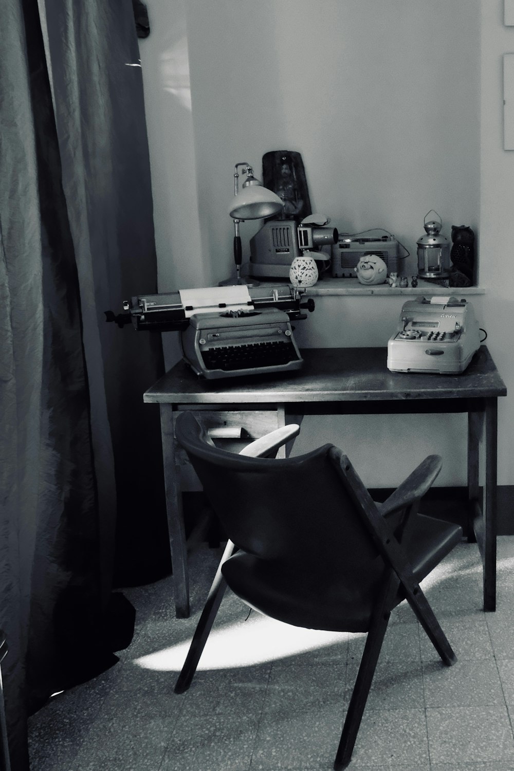 コンピューターテーブルの近くにある黒い革のパッド入り金属フレームの椅子