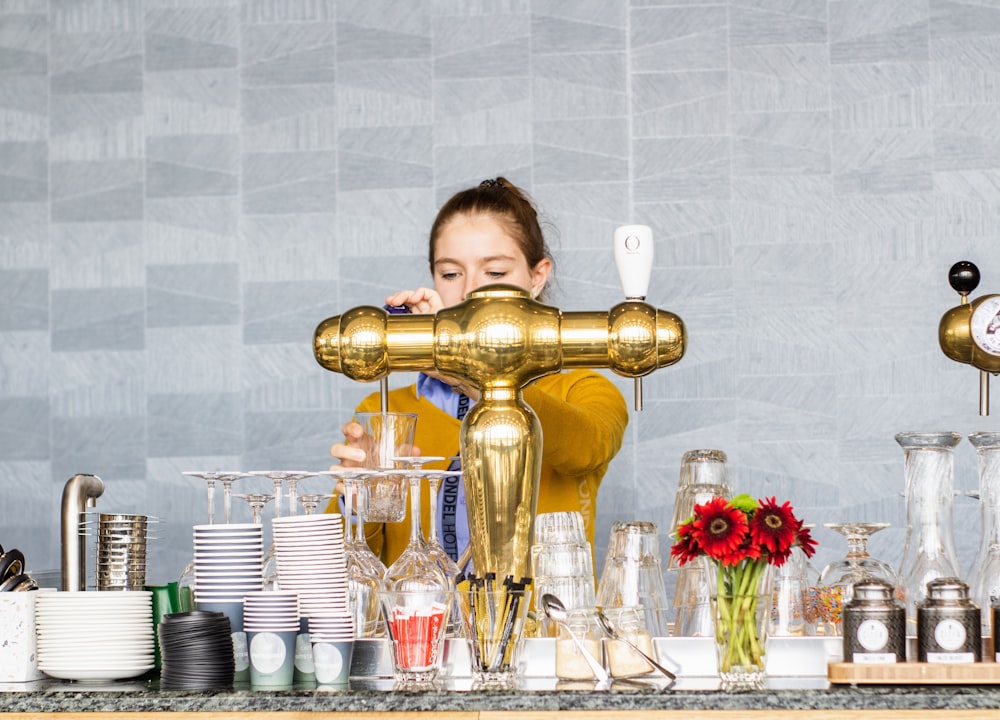 woman pouring liquor on clear drinking glass