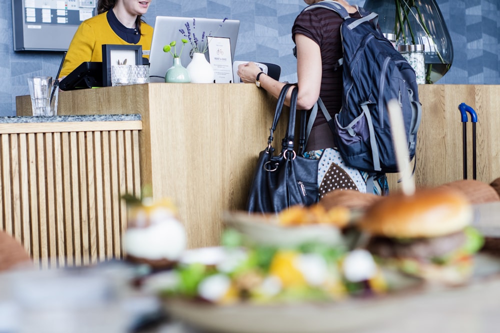 woman in multiple bags at a receptionist