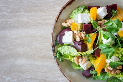 bowl of vegetable salad with walnuts salad teams background