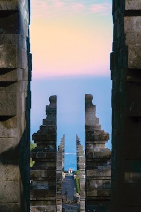 Wide shot of an Olympus gate framed by a serene blue-toned landscape.