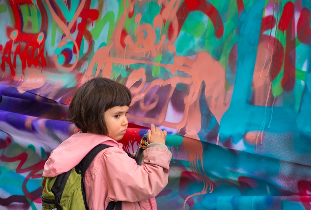 girl wears backpack in front painted garment