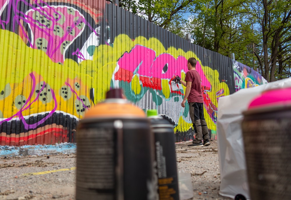 man drawing graffiti on wall