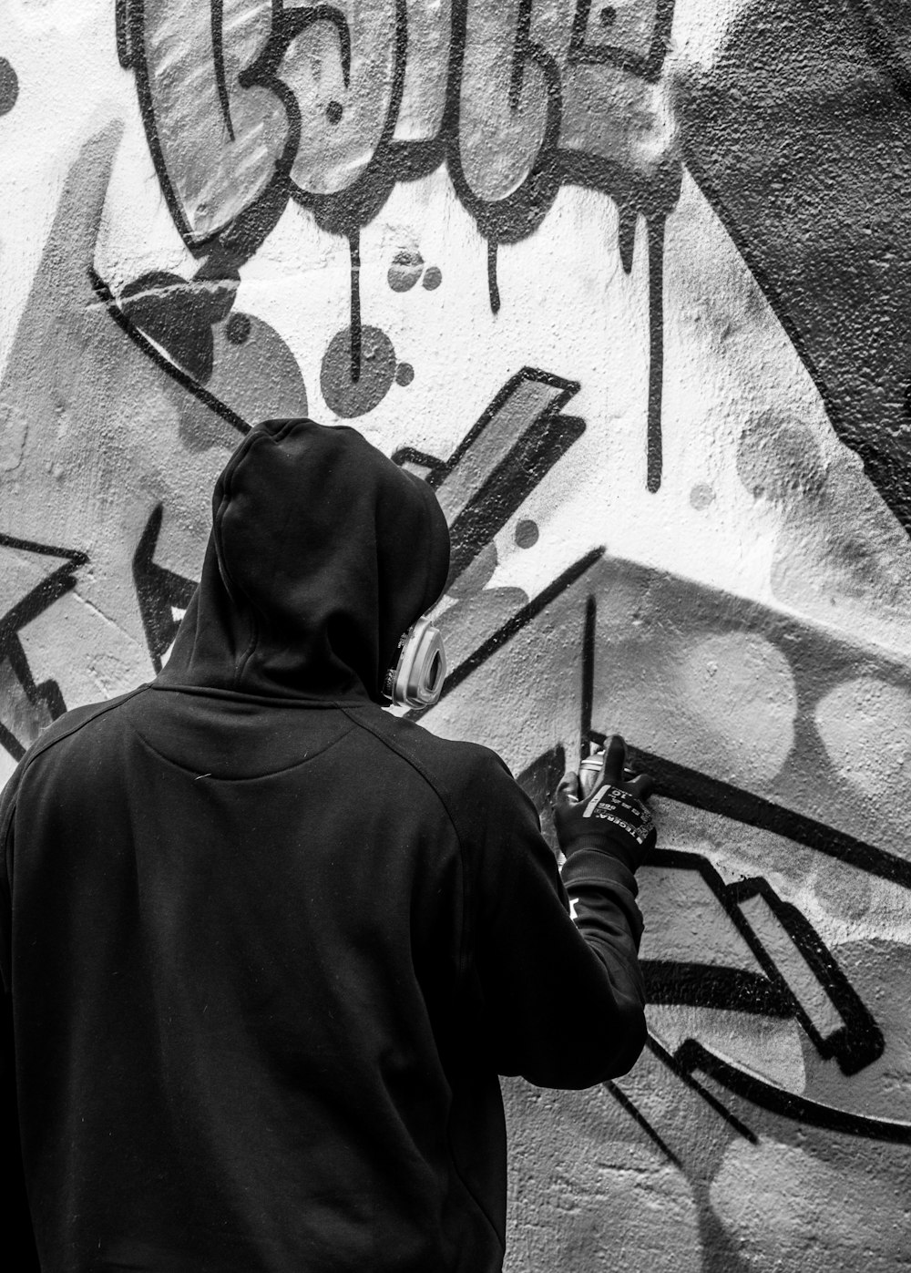 Photographie en niveaux de gris d’une personne peignant sur un mur