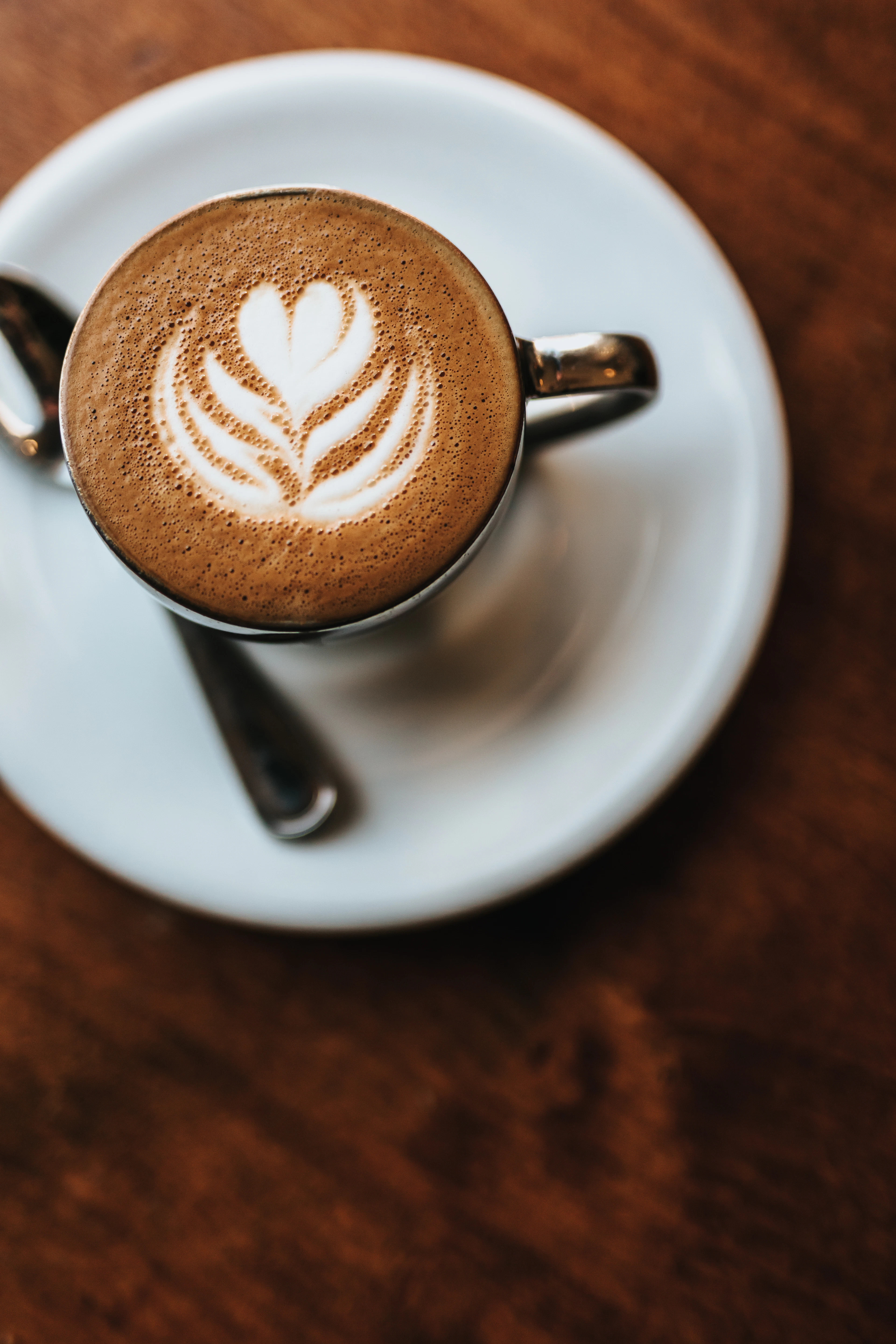 A milky coffee in a dark cup on a table