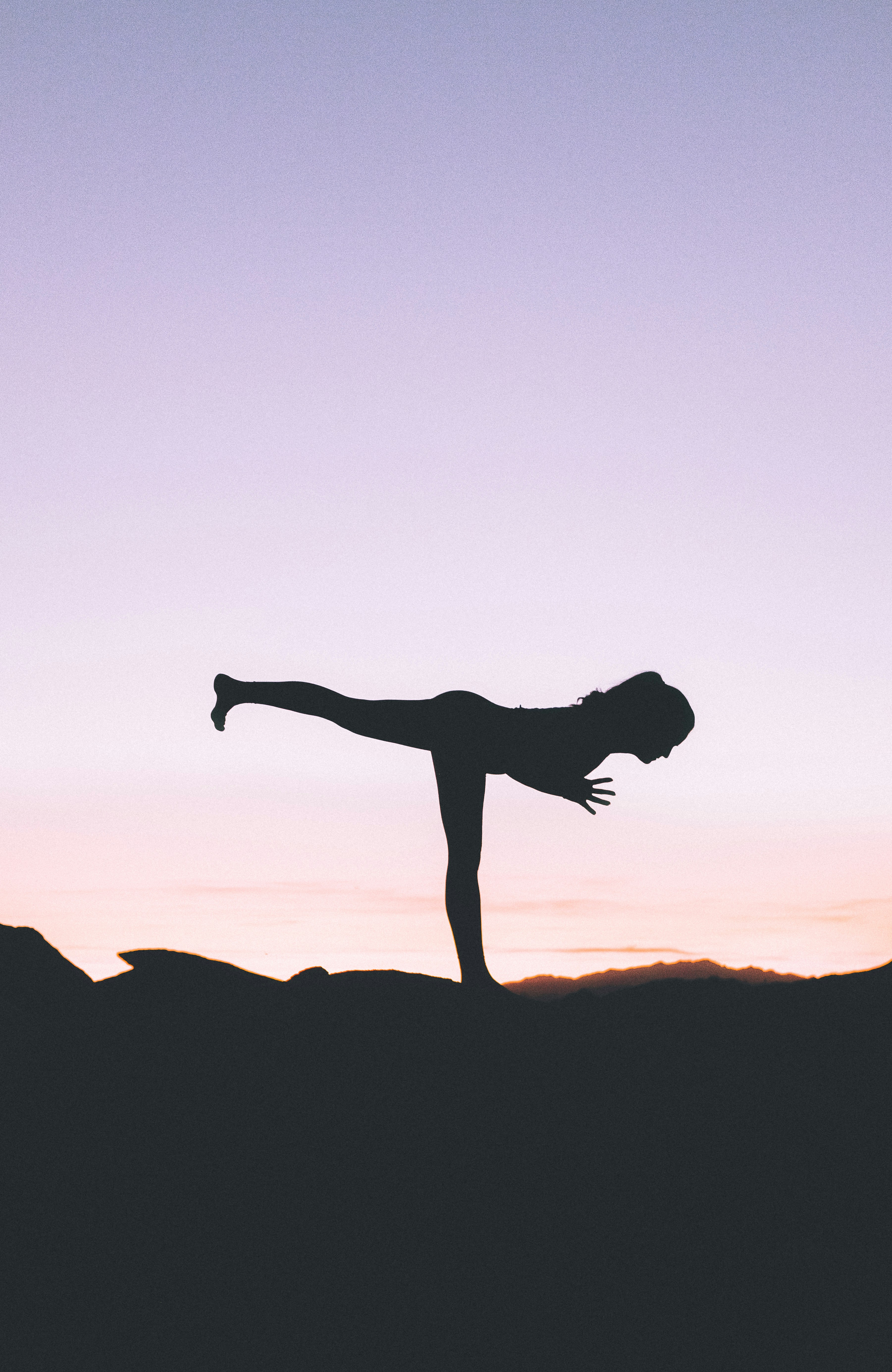 silhouette photography of woman standing on right foot