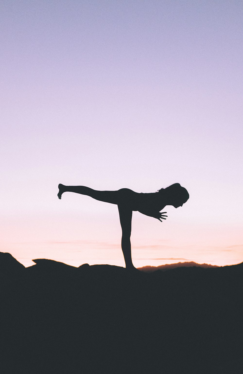 Photographie de silhouette de femme debout sur le pied droit