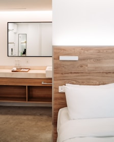 A spacious wooden bed with a sleek headboard in a modern bedroom.
