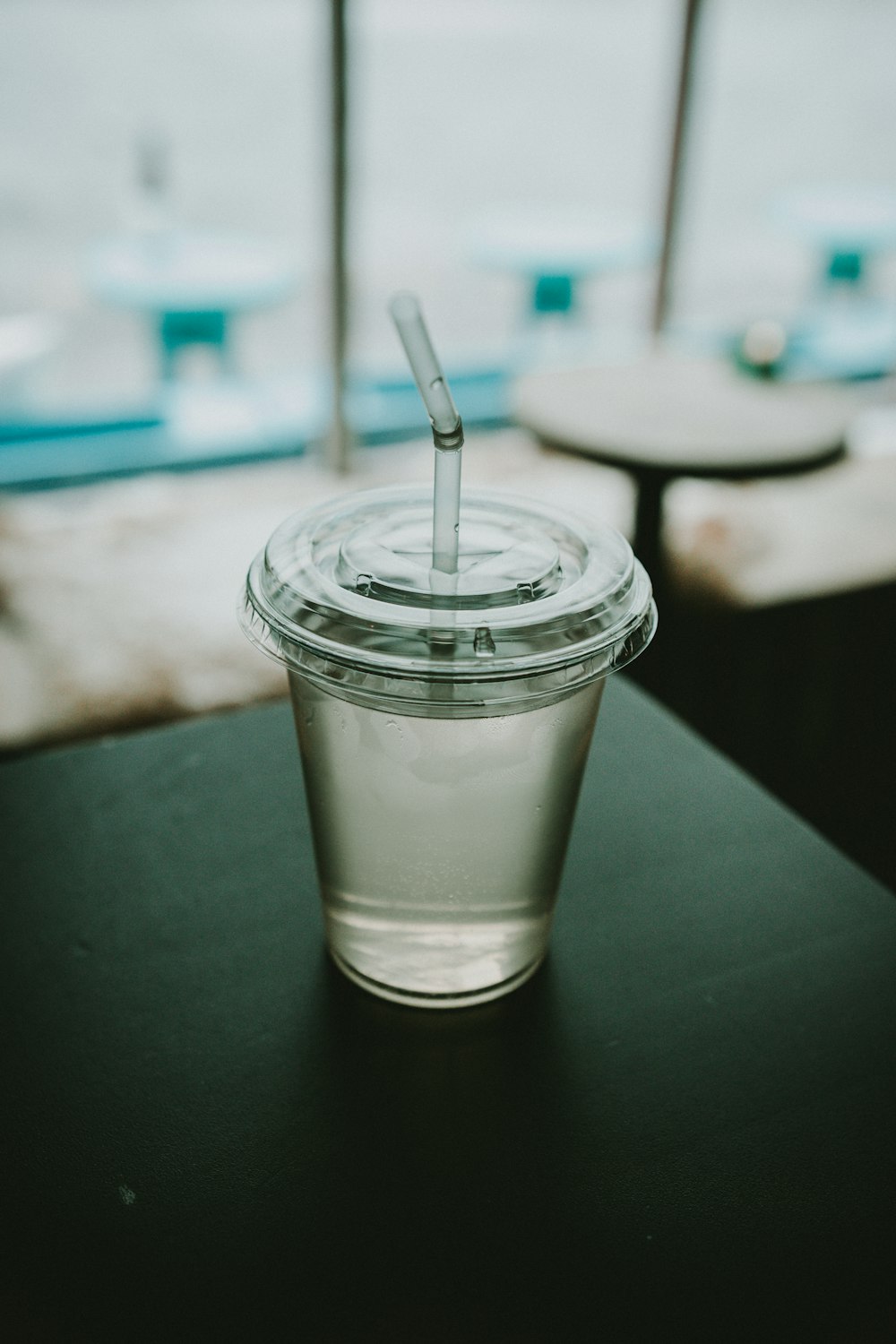 黒い表面の上に透明なプラスチック製の使い捨てカップ