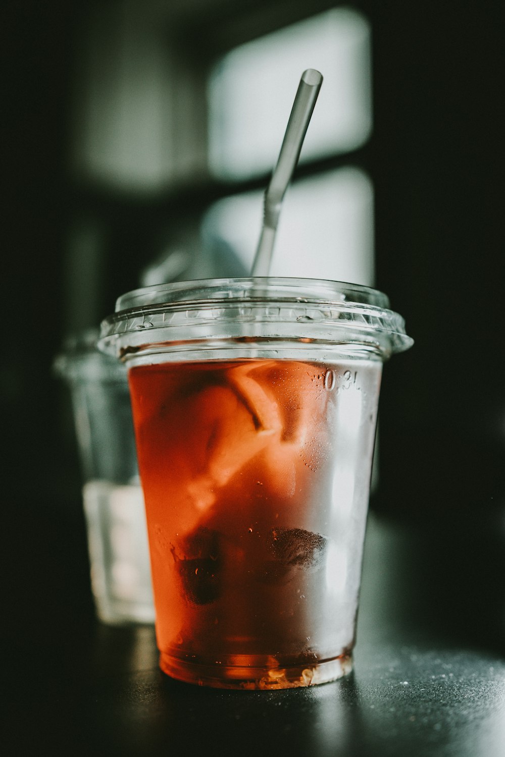 赤い液体が入った透明な使い捨てカップのセレクティブフォーカス写真