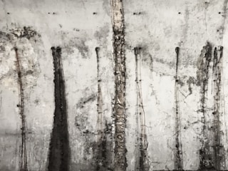 A textured concrete wall with vertical streaks and patterns from stains or weathering, giving it an old and industrial appearance.