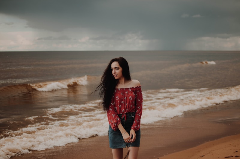 smiling woman standing beside seashore during daytime