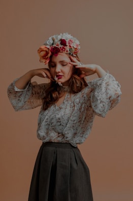 Close-up of a young quinceañera smiling softly in natural light, wearing a delicate floral crown.