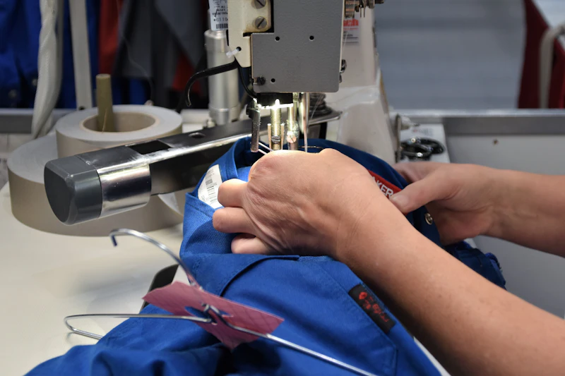 Hands guiding fabric through an industrial sewing machine