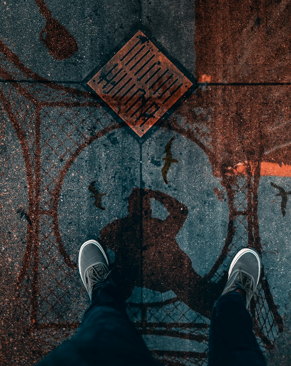 man standing on the street with reflection on water