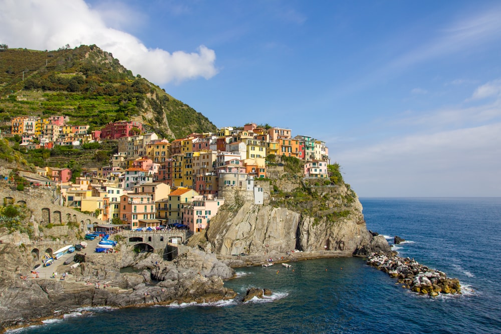 buildings in a cliff near body of water during daytime