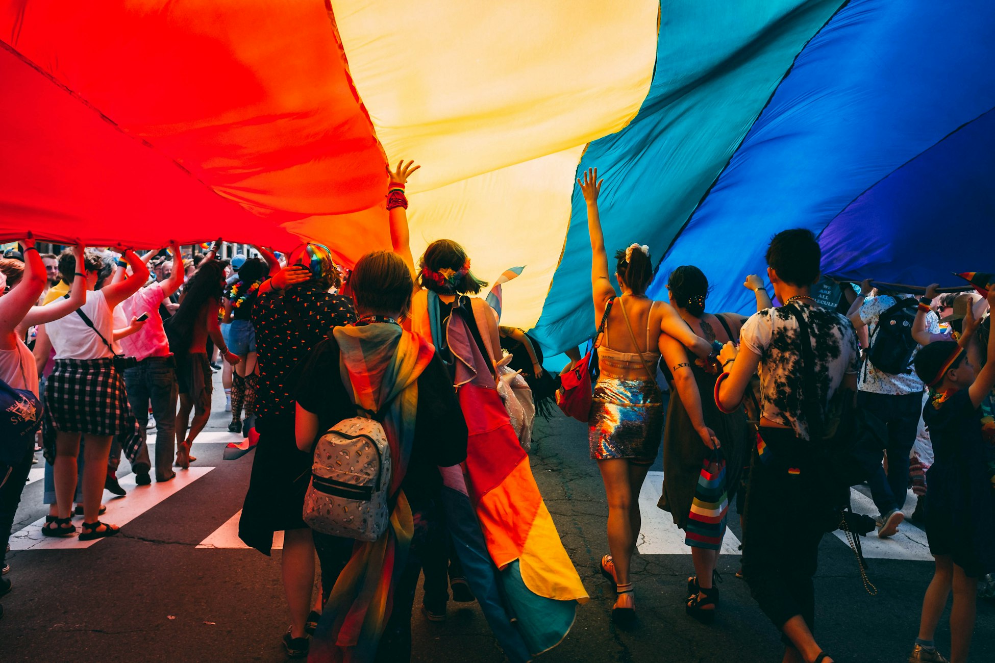 Demonstrators under a rainbow gay pride flag in Portland, Maine, in June 2019 (Mercedes Mehling via Unsplash)