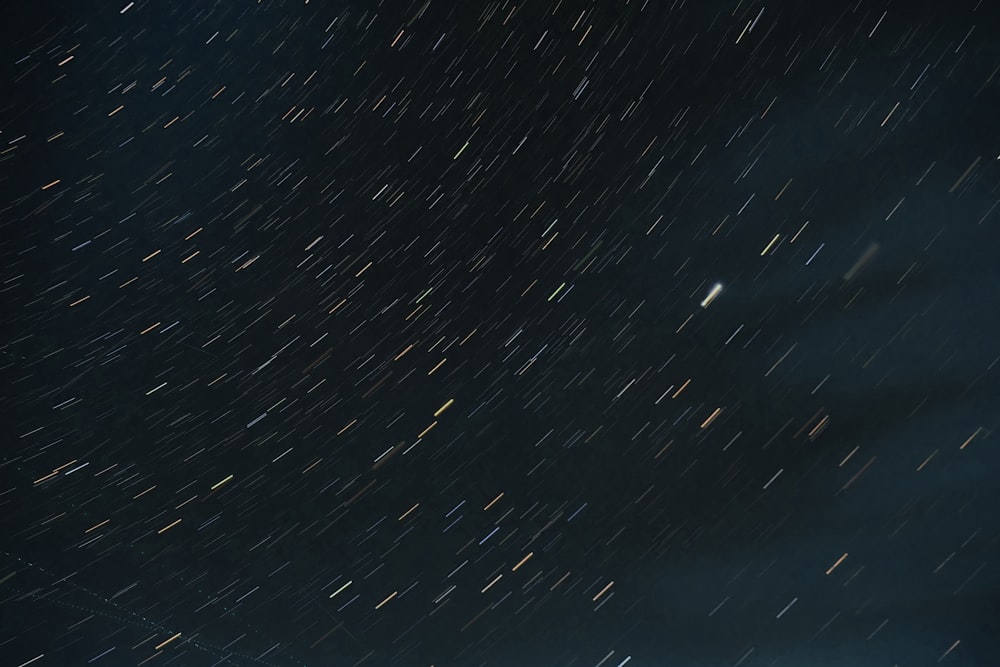 a night sky with stars moving across the sky