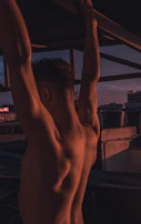 An inspiring photo of a muscular athlete stretching outdoors at sunrise.