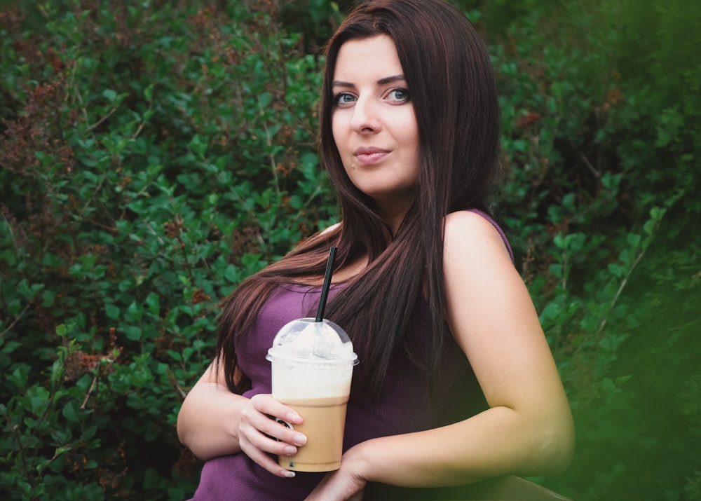 woman in a maroon top holding a frappe