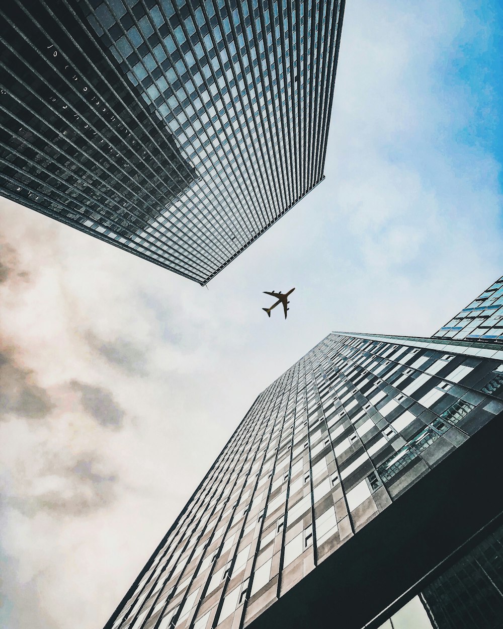 plane flying over two building during daytime