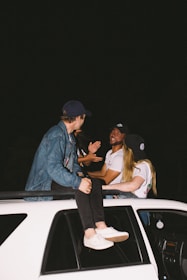 A group of friends getting into a taxi at night, smiling and ready to go.