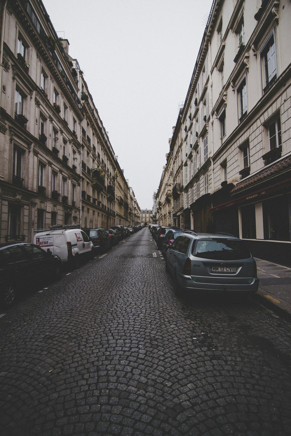 car lot in a road between buildings during daytime