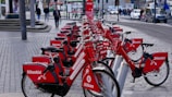 A lively street in Seville with colorful rental bikes lined up for use.