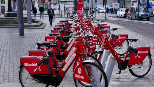 A lively street in Seville with colorful rental bikes lined up for use.