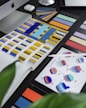 Close-up of a designer’s workspace with sketches and color swatches in blue, violet, and gold tones.