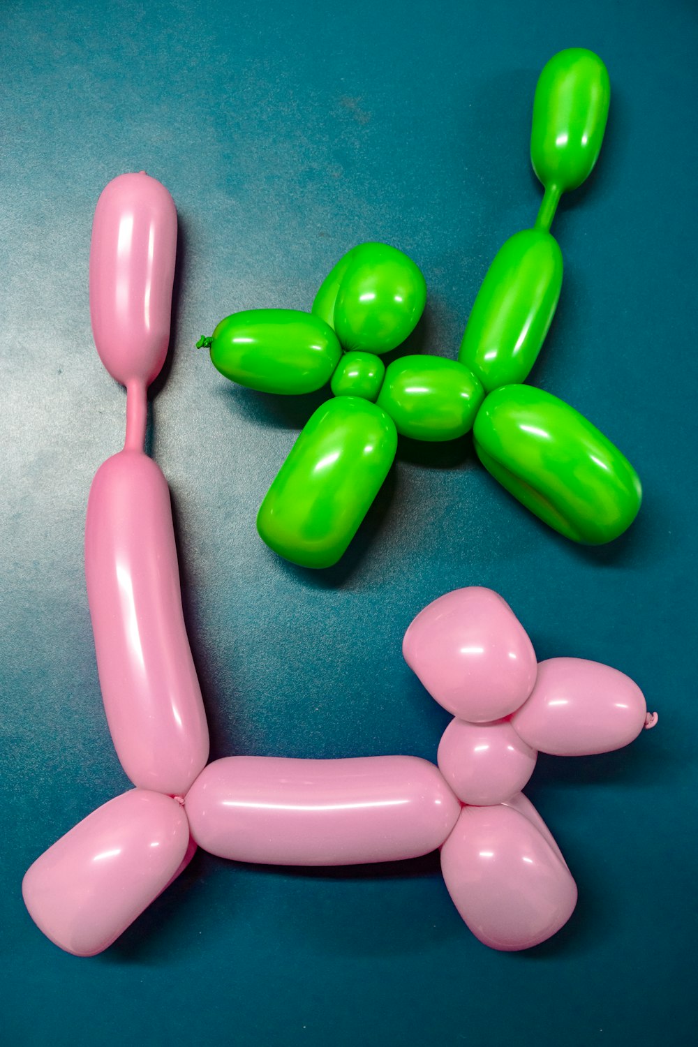 two green and pink animal figure balloons